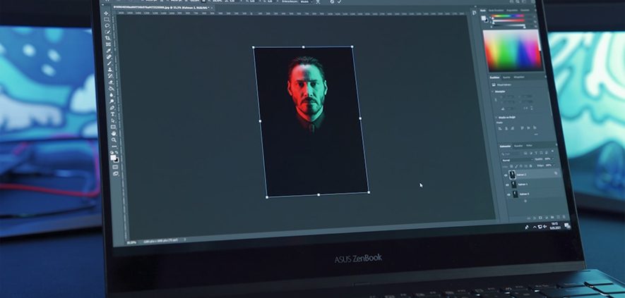 Laptop screen showing Keanu Reeves in Photoshop, illuminated by red and green lights.