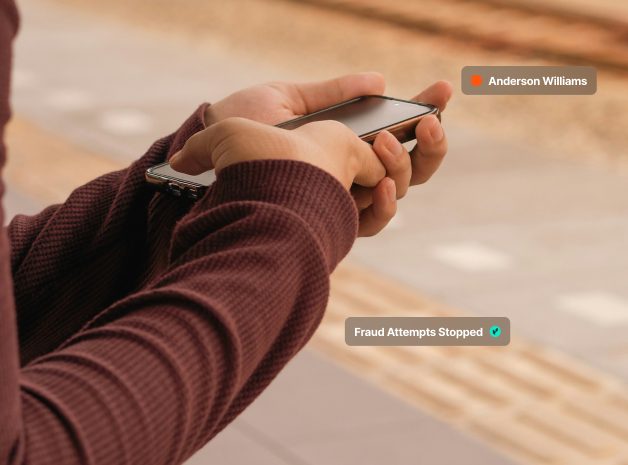 Person holding a smartphone with fraud alert notifications visible.